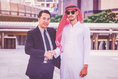 Arapça işadamı bir el sıkışma iş ortağı inşaatta veriyor.