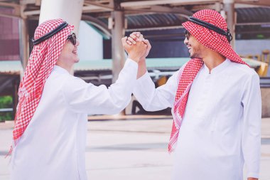 Arapça işadamı bir el sıkışma iş ortağı inşaatta veriyor.