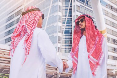 Arapça işadamı bir el sıkışma iş ortağı inşaatta veriyor.