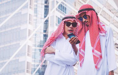 İki Arap iş adamları şehirde bir cep telefonuna ileti