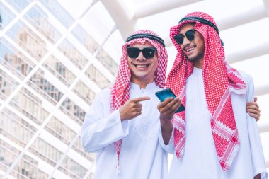 İki Arap iş adamları şehirde bir cep telefonuna ileti