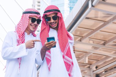 İki Arap iş adamları şehirde bir cep telefonuna ileti