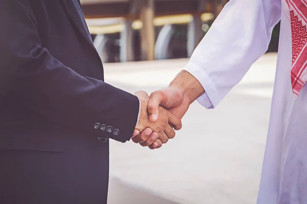 Arabic businessman giving an handshake to his business partner, on construction site