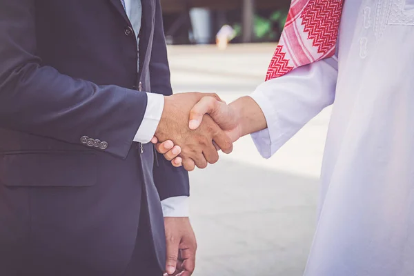 Arabic businessman giving an handshake to his business partner, on construction site