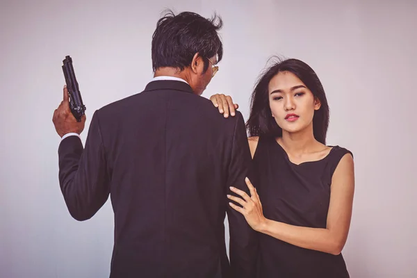 Young couple hugging and posing with gun