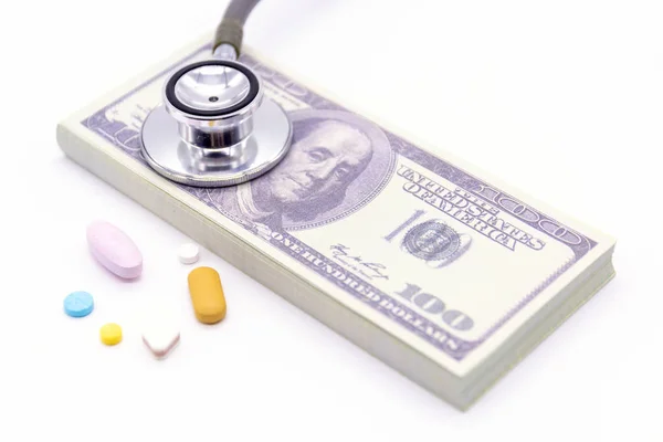 Stethoscope with dollar bank and medicine capsules on white back — Stock Photo, Image