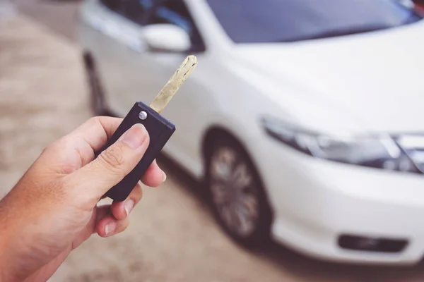 Man holding car keys with car on background — Stock Photo, Image