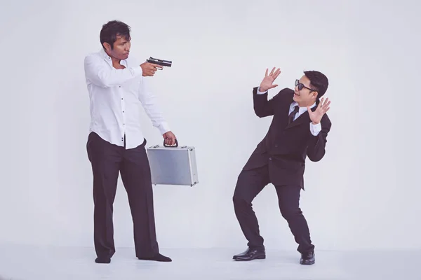 Man carrying a gun to rob the briefcase. — Stock Photo, Image