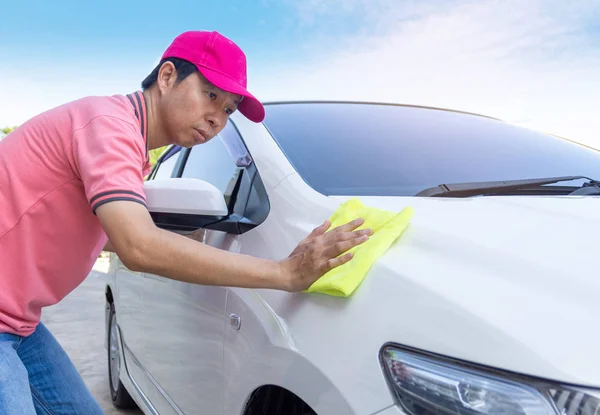 Auto service staff cleaning car with microfiber cloth