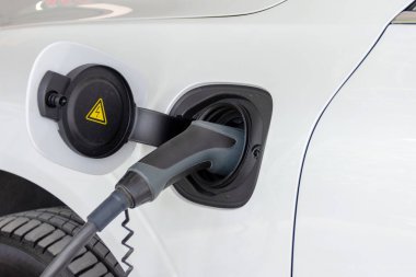 Elektrikli araba aküsünü şarj ediyorum.