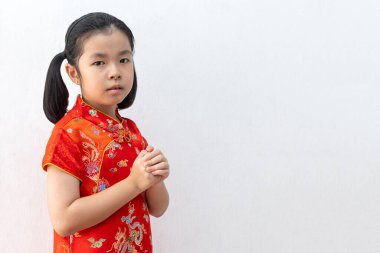 Asyalı kız tebrik jesti olarak Cheongsam giyer, selamlaşmak için elleri birleştirir. Çince Yeni Yıl