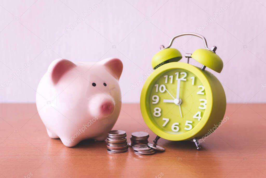 Piggy bank, alarm clock and coins. for growing business. time to saving concept.