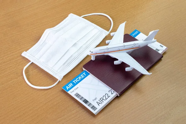 Travel during the covid-19 pandemic. airplane model with face mask, air ticket and passport. ready for holidays.