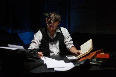 Masada oturmuş ne yazacağını düşünen bir yazarın portresini yakından çek. Onun bir elinde bir kitap, diğer elinde bir sigara var. Masanın üzerinde antika bir daktilo, bir bardak viski, bir kül tablası, kitaplar var..