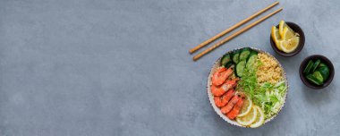 Yemek çubukları üst görüşlü Asya salatası. Gri taş arka planda karides kasesi. Sağlıklı ve dengeli gıda kavramı