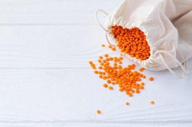 Eko pamuklu kırmızı mercimekler beyaz tahta masaya yakın çekimde fotokopi alanı ile