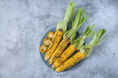 Izgara mısır koçanlarıyla otlar, tuz ve baharatlar. Yaz vejetaryen yemekleri