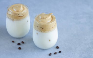 Buzlu soğuk Dalgon kahvesi ve bardakta süt. Krem şantili Kore mutfağı kahvesi.