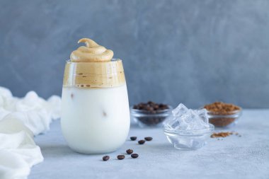 Kahve çekirdekleri ve buz küpleriyle birlikte bir bardak lezzetli DALGON kahve içeceği. Boşluğu kopyala