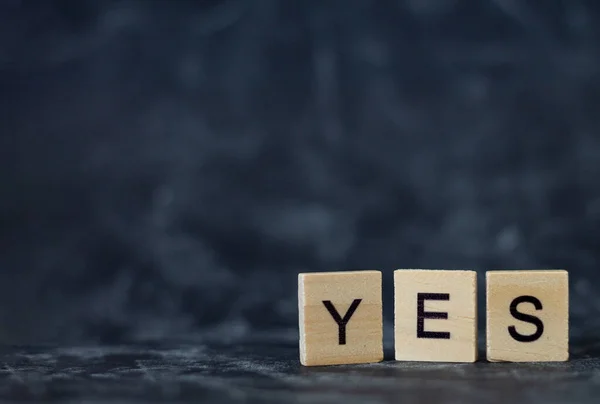 Wooden letters spelling out the word YES