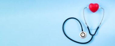 Doktor masasında kırmızı kalpli steteskop.