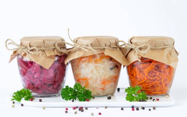 Pickled fermented vegetables in glass jars ready for eating clipart