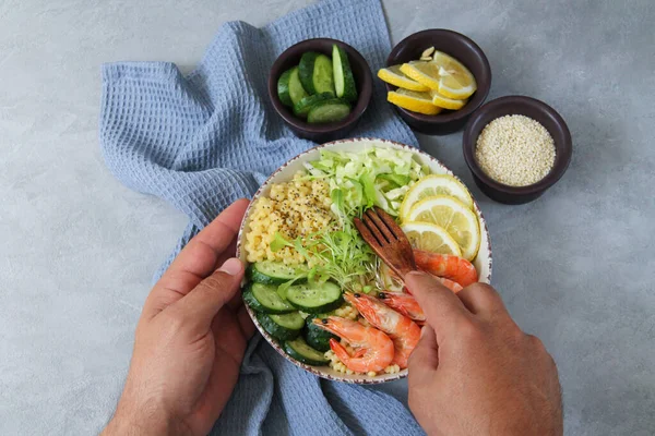 Man eating healthy and balanced salad with vegetables, seafood and seeds