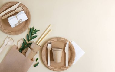 Bej arka planda çevre dostu tek kullanımlık sofra takımı. Hiç atık ve geri dönüşüm kavramı