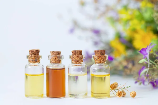 Flessen Met Biologische Essentiële Aromaoliën Wilde Bloemen Gedroogde Kruiden Achtergrond — Stockfoto