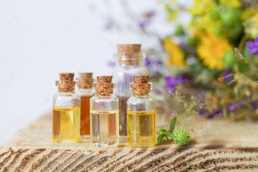Small bottles with essential oils on wooden table. Alternative medicine concept