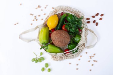 Beyaz arka planda sağlıklı yiyeceklerle dolu bir alışveriş çantası.