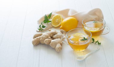 Nane yaprağı ve limonlu iki bardak sağlıklı zencefil çayı. Metnin için boşluk