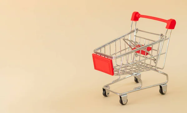Empty Red Shopping Cart Trolley Beige Background Copy Space — Stock Photo, Image