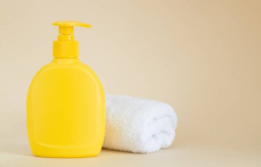Bej arka planda beyaz havlunun yanında sarı markasız şeker şişesi.
