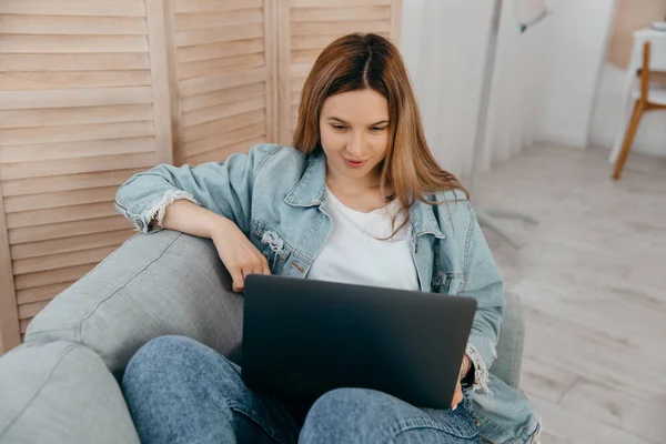 Student Młoda Dziewczyna Leżąca Kanapie Domu Patrzy Ekranie Laptopa Biorąc — Zdjęcie stockowe