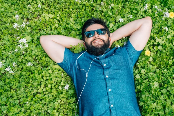 Беззаботный Человек Солнечных Очках Лежит Траве Слушает Весеннюю Музыку — стоковое фото