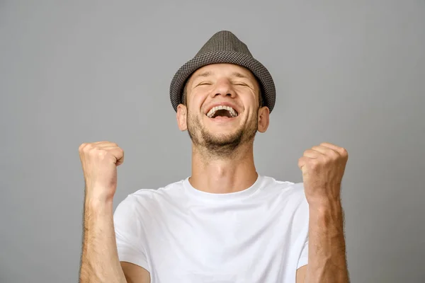 Felice Giovane Uomo Con Braccia Alzate Segno Vittoria Sfondo Grigio — Foto Stock