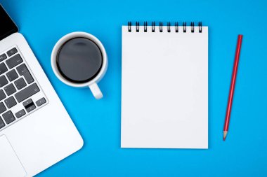 Modern mavi ofis resepsiyon masası dizüstü bilgisayar ve giriş metni boş defter sayfası. Üstten Görünüm, düz yatıyordu