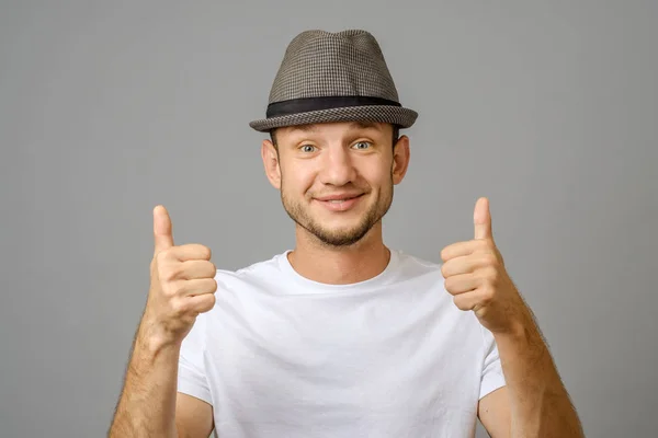 笑顔と灰色の背景上に つの親指を表示の男のポートレート — ストック写真