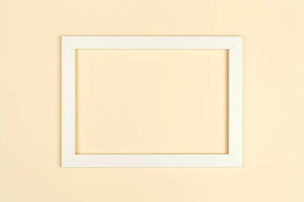 Abstract blank picture frame flat lay on textured pastel colored paper background. Minimalist picture frame mockup