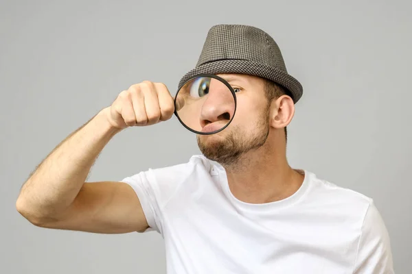 Uomo Stupito Guardando Attraverso Una Lente Ingrandimento Sfondo Grigio — Foto Stock