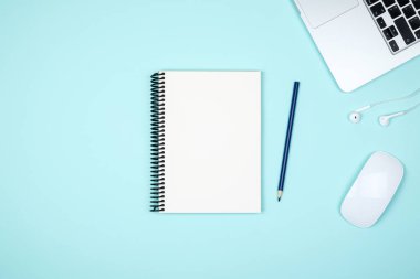 Modern mavi ofis resepsiyon masası dizüstü bilgisayar ve giriş metni boş defter sayfası. Üstten Görünüm, düz yatıyordu