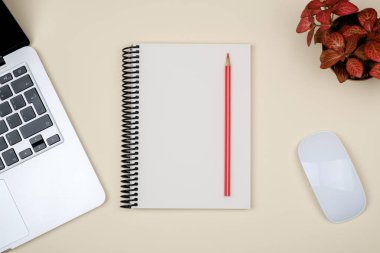 En az işyeri dizüstü bilgisayar ve renkli arka plan üzerinde boş not defteri. Üstten Görünüm. Düz yatıyordu