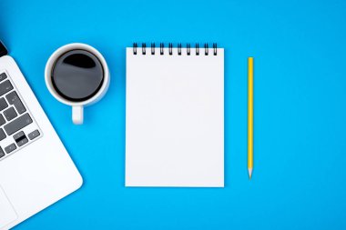 Modern mavi ofis resepsiyon masası dizüstü bilgisayar ve giriş metni boş defter sayfası. Üstten Görünüm, düz yatıyordu