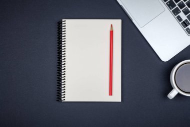 En az işyeri dizüstü bilgisayar ve renkli arka plan üzerinde boş not defteri. Üstten Görünüm. Düz yatıyordu