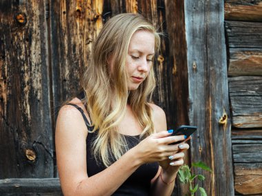 Güzel genç çilli kadın arka plan üzerinde bir köylünün ev telefonu kullanarak