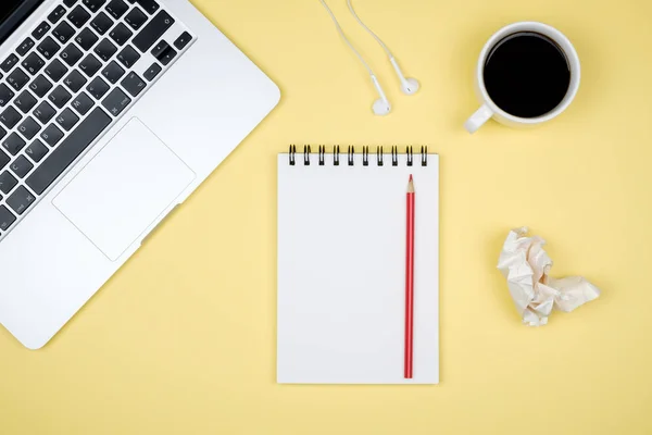 Minimal working desk with laptop and blank notepad page. Top view, flat lay and copy space