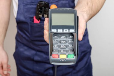 Banka ödeme terminalini tutan araçlara sahip adam