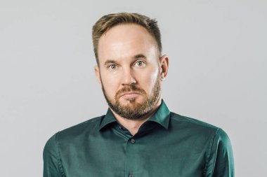 Şaşkın genç sakallı adam ayakta ve omuz silkme