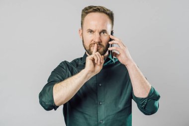 Dudaklarında işaret parmağı olan adam, sessiz olmak isteyin